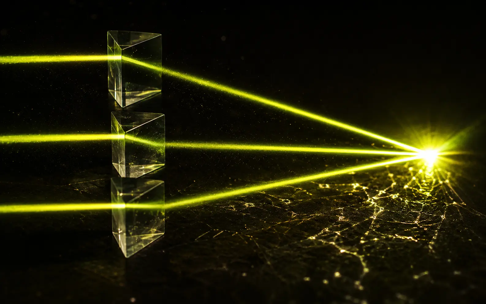 Three streams of light refracting through glass and converging into a single bright node.